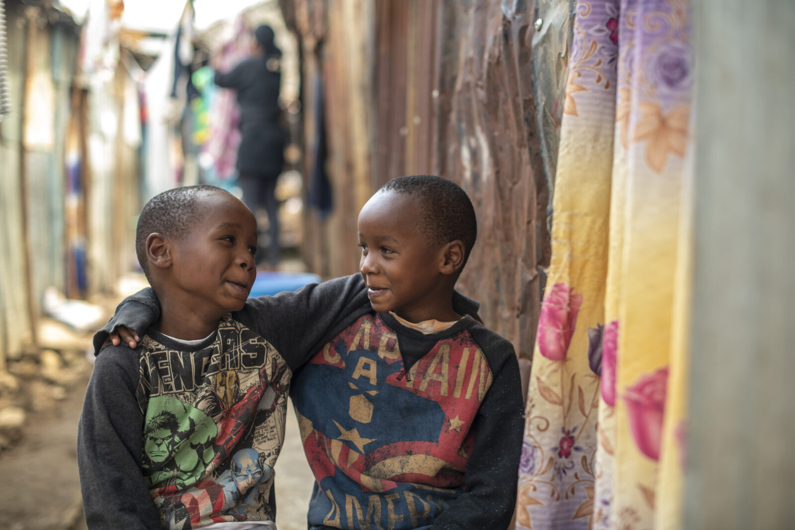 twee jongentjes uit kenia staan met armen over elkaars schouders